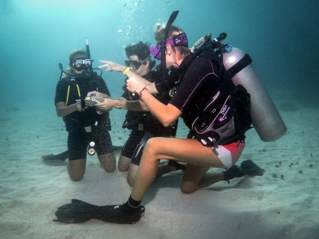 Instructor+giving+students+direction+underwater